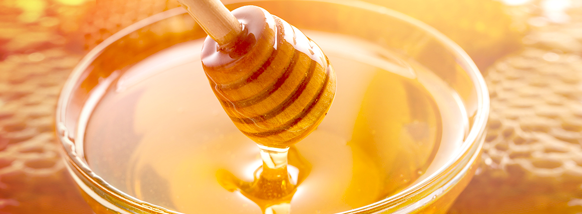 Honigtopf mit fließendem gelben Honig
